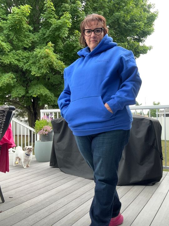 Customer April wearing a blue Comfrt hoodie outdoors